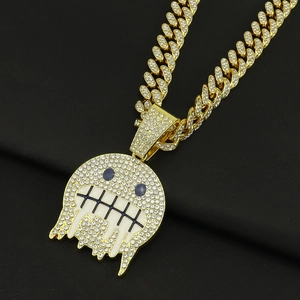 Dettaglio catena cubana hip hop con ciondolo emoji e strass bianchi brillanti