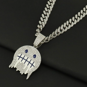 Dettaglio del ciondolo emoji ghiacciato con occhi blu e catena cubana in argento uomo