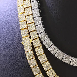 Détail de colliers gourmette en or et argent avec maillons carrés et zircons pavés