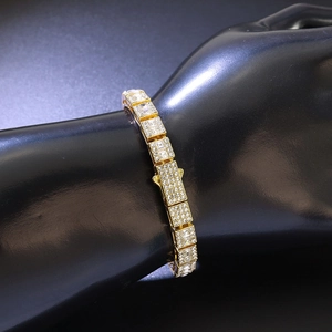 Gros plan d'un bracelet hip-hop doré avec maillons carrés sertis de zircons cubiques
