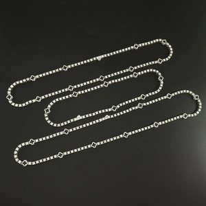 Detailansicht der silberfarbenen Tenniskette mit schwarzen Kleeblatt-Anhängern und Zirkonia
