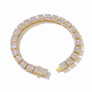 Détail du collier à maillons carrés dorés serti de cristaux de zircone sur fond blanc