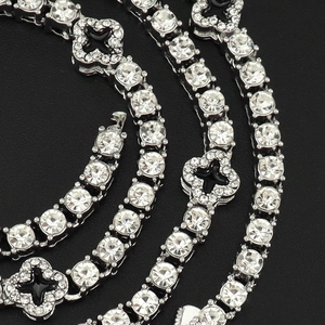 Nahaufnahme der glitzernden Tenniskette mit schwarzem Kleeblatt und Silber-Zirkonia