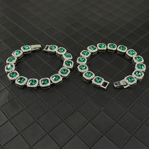 Detail of 13mm emerald green square cut sugarloaf Cuban link bracelets with white crystals