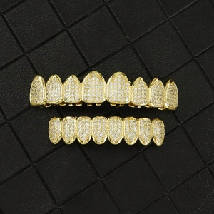 Macro shot of gold plated hip hop grillz set with micro paved zircon on leather background