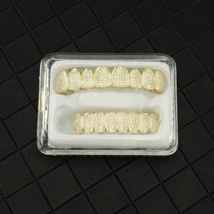 Detail of hip-hop gold plated grillz with zircon stones in a transparent gift box