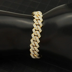 Gros plan d'un bracelet gourmette doré serti de strass brillants sur présentoir noir