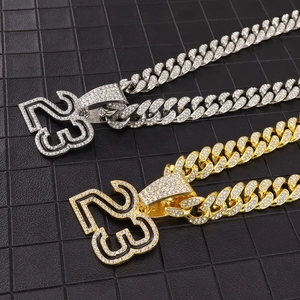 Close-up of iced out number 23 pendant on a heavy Cuban link chain with white crystals
