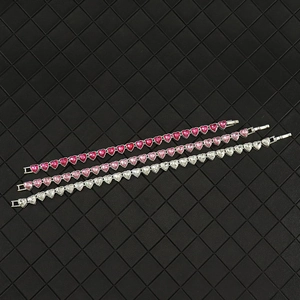 Detail von 8mm Herz-Kristall-Tennisarmbändern in Rot, Rosa und Weiß auf Lederhintergrund