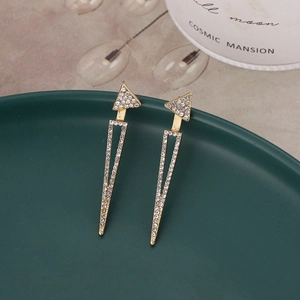 Gros plan de boucles d'oreilles dorées géométriques avec cristaux étincelants