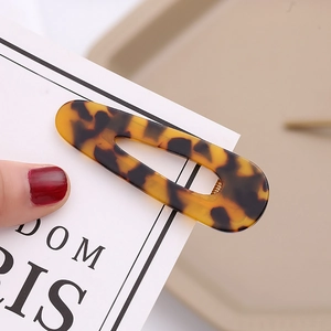 Close-up of leopard print acetate hair clip with hollow teardrop design and glossy finish