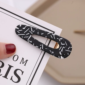 Elegant leopard print acetate hair clip in black and white with a gold metal duckbill base