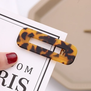 Detailed close-up of a tortoiseshell acetate hair clip with golden metal spring