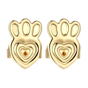 Detailed macro view of gold crown-heart earring lifters with amber gemstone inlays