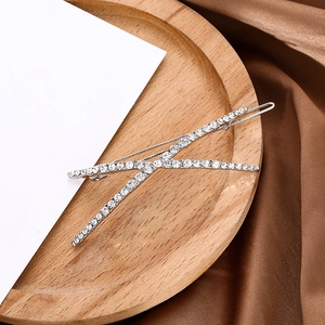 Macro detail of V-shaped hair clip with white rhinestones on silver alloy base