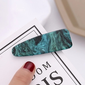 Green and blue marble pattern hair clip with silver glitter on a white card