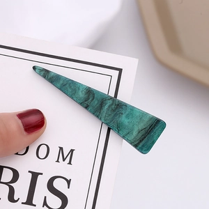 Detailed close-up of dark green marble patterned hair clip with fine glitter finish