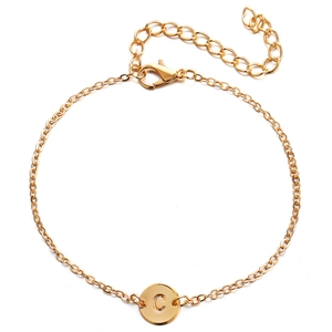 Gold chain bracelet with round charm featuring an engraved letter C and lobster clasp