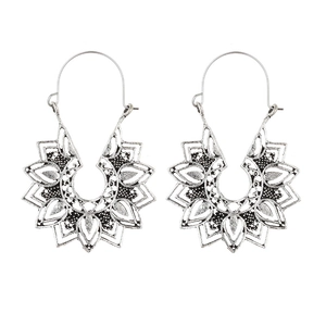 Macro shot of silver hollow mandala earrings with vintage oxidized metal texture
