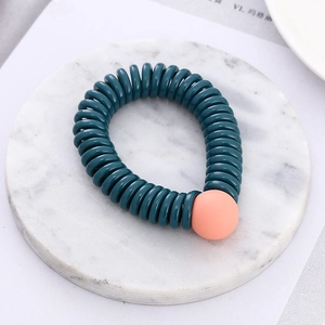 Spiral telephone cord hair tie in teal with matte peach bead on white marble