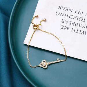 Close-up of diamond-encrusted gold key pendant with adjustable sliding clasp chain