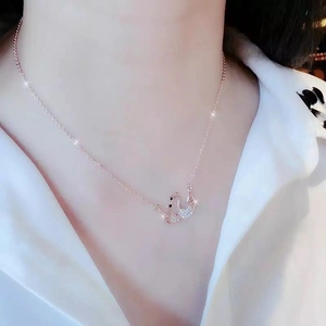Detail van de dubbele zwaan hanger met witte zirkonia op een roségouden ketting