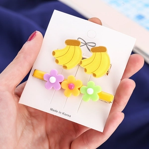 Detail of sweet floral and banana hair clips set on a display card for women
