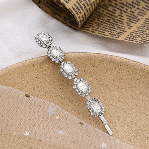 Barrette à cheveux argentée avec cinq cristaux rectangulaires et détails en strass perle