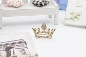 Macro detail of golden crown hair clip featuring sparkling rhinestones and elegant design