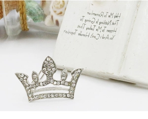 Detailed view of crown-shaped hair clip with sparkling silver rhinestones and crystals
