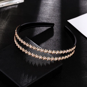Close-up of sparkling champagne rhinestones in floral patterns on a black double-layer headband