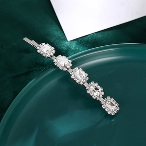 Détail de la barrette en argent avec cristaux et strass sur fond en velours vert