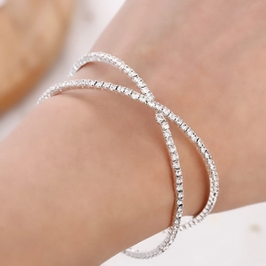 Detailed close-up of a silver crossover bangle with shimmering rhinestones on a wrist