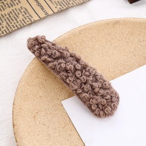 Nahaufnahme der braunen Teddy-Plüsch-Textur auf einer langen Winter-Haarspange für Damen