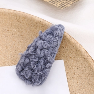 Detail of grey-blue lamb wool hair clip with soft fuzzy texture for autumn and winter