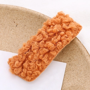 Plush orange faux fur rectangle hair clip for women and girls on a minimal beige display