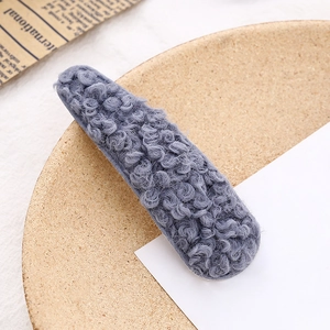 Blaugraue Plüsch-Teddywolle BB-Haarklammer auf einem Korktablett mit eleganter Ästhetik