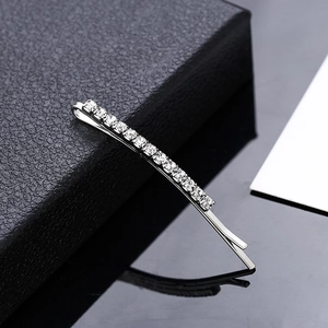 Sparkling silver metal hair pin with a row of clear rhinestones on a leather background