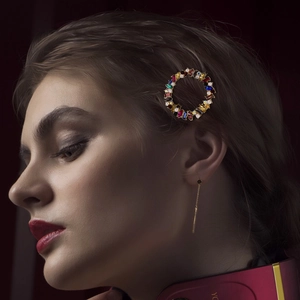 Eleganter runder Haarclip mit farbigen Kristallen und Perlen auf goldfarbener Legierung