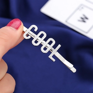 Dettaglio del fermaglio per capelli in argento con scritta COOL tridimensionale