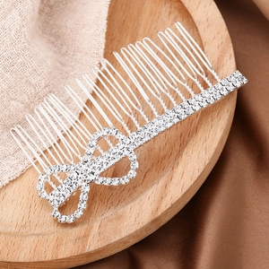 Peigne à cheveux de mariée argenté élégant avec nœud en strass sur un plateau en bois