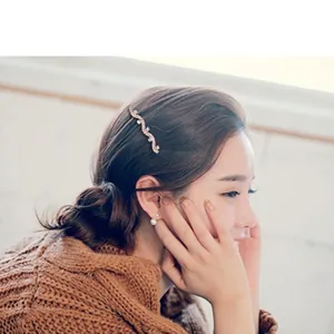 Elegant bridal gold wave hair comb with rhinestones and pearls on Asian model side view