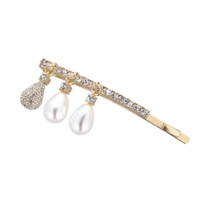 Dettaglio del fermaglio dorato per capelli con strass lucidi e ciondoli di perle