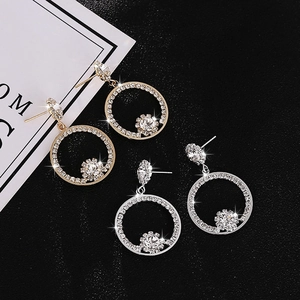 Sparkling hoop earrings with suspended round cubic zirconia in gold and silver finishes