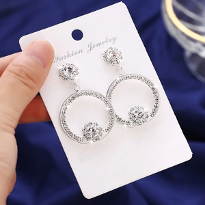 Elegant silver circle drop earrings with shimmering zircon floral accents on card