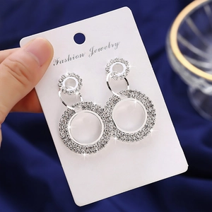 Sparkling rhinestone double hoop drop earrings with translucent bead on navy velvet background