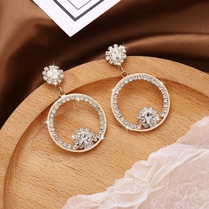 Elegant gold drop earrings with diamond-encrusted circles and daisy floral design