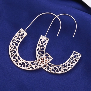 Elegant rose gold hollow geometric earrings with heart pattern on blue silk fabric