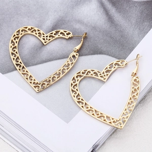 Elegant gold filigree heart hoop earrings with intricate floral pattern in a matte finish