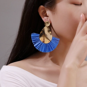 Exaggerated bohemian fan-shaped earrings with blue raffia fringe and gold metallic detail